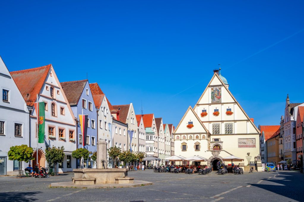 Escort Weiden - Sonniger Marktplatz in der Innenstadt mit Brunnen und Biergarten