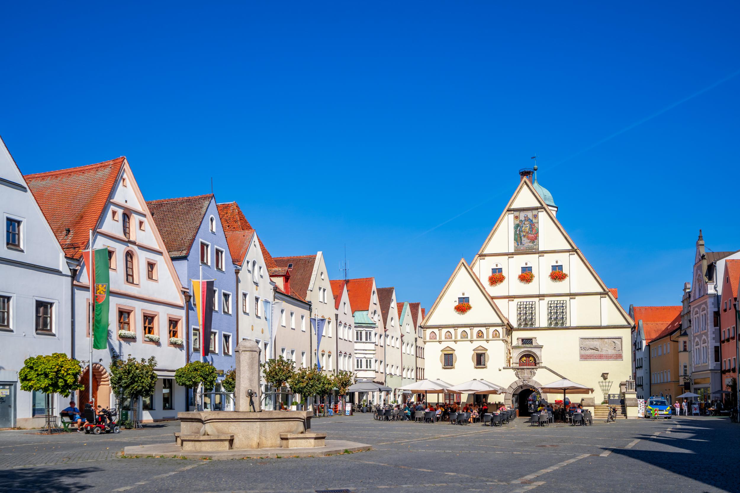 Escort Weiden - Sonniger Marktplatz in der Innenstadt mit Brunnen und Biergarten